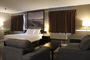 Habitación de hotel con 1 cama y 2 sillas en Super 8 by Wyndham Kamloops On The Hill en Kamloops