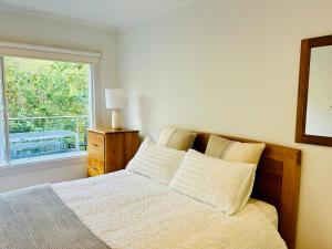 桑迪灣的住宿－Sandy Bay Haven，一间卧室配有一张带窗户的床和一张四柱床