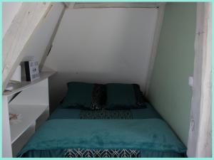 een kleine slaapkamer met een bed op zolder bij 04 Le Pied-à-terre by Fannny S in Saint-Quentin