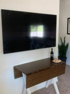 einen großen Flachbild-TV, der an einer Wand hängt in der Unterkunft Den Street Cottage in Los Alamos