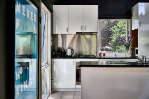 a kitchen with white cabinets and a window at Boatshed Villa Green Door in Daylesford