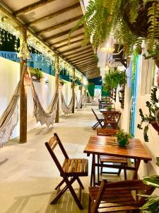 un patio con tavoli e amache in un edificio di Flats Corais a Maragogi