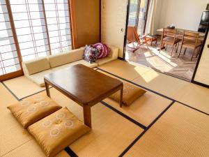 sala de estar con sofá y mesa en 【MeTeL】窓辺から壮大な富士が拝める。リノベーション済み一等貸し宿泊施設 en Nishikatsuracho
