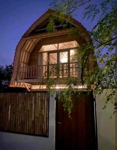 a house with a balcony on top of it at Puri Jineng Uluwatu 4 in Uluwatu