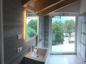 a bathroom with a sink and a large window at Hotel Resort Le Vele in Domaso