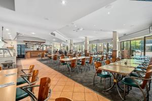 a restaurant with tables and chairs and windows at Sherbourne Terrace Hotel in Shepparton