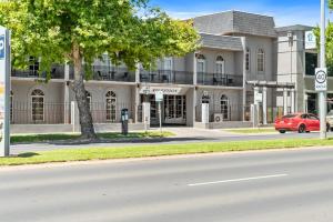 谢珀顿Sherbourne Terrace Hotel的一辆红色汽车停在一栋建筑物前