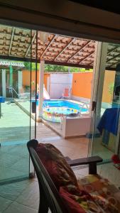 a view of a swimming pool through a glass window at Pousada paraiso das conchas hostel in Cabo Frio