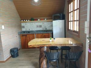 a kitchen with a large wooden table and chairs at Refúgio Verde - Cabana Quero-Quero in Nova Petrópolis
