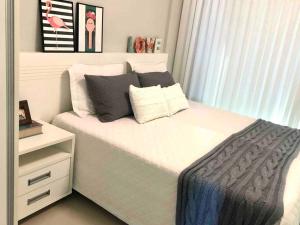 sypialnia z białym łóżkiem i białą komodą w obiekcie Muito confortável, vista do mar, todo climatizado w mieście Bombinhas