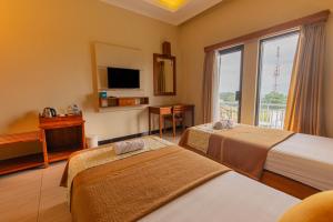 a hotel room with two beds and a window at Hotel Griya Katarina in Ambarawa