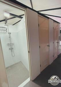 uma cabina de duche ao nível do chão num quarto com uma porta de vidro em Camp Backpackers Port Barton em San Vicente