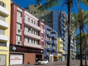 a white car parked in front of a building at Hotel Elevado in Porto Alegre