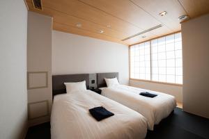 大阪的住宿－Welina Hotel Premier Osaka Namba，两张睡床彼此相邻,位于一个房间里