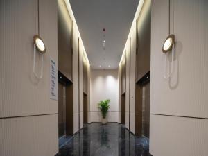 um corredor com uma planta no meio de um edifício em Holiday Inn Express Shenzhen Futian Center, an IHG Hotel em Shenzhen