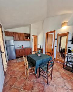 a kitchen and dining room with a table and chairs at Domos de Ammentos in Tortolì