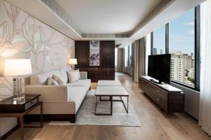 a living room with a white couch and a tv at JW Marriott Hotel Bangkok in Bangkok