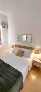 1 dormitorio con 1 cama blanca grande y 2 mesas en Bem Localizado Botafogo, en Río de Janeiro