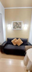um sofá preto numa sala de estar com duas almofadas em Bem Localizado Botafogo no Rio de Janeiro