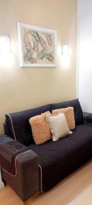 a black couch with pillows and a table in a room at Bem Localizado Botafogo in Rio de Janeiro