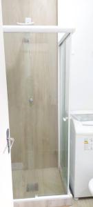 a shower with a glass door next to a toilet at Bem Localizado Botafogo in Rio de Janeiro