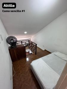 a bedroom with a bed and a staircase with a fan at Encanto en Cartagena, aparatamento Duplex con vista al mar in Cartagena de Indias