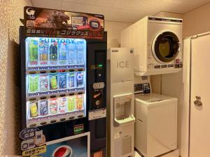 a vending machine in a room with a refrigerator at Hop Inn Tokyo Iidabashi in Tokyo