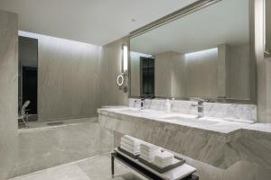 a bathroom with two sinks and a large mirror at JW Marriott Hotel Bangkok in Bangkok