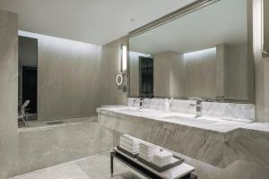 Un baño con dos lavabos y un espejo grande. en JW Marriott Hotel Bangkok, en Bangkok