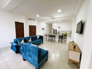 uma sala de estar com um sofá azul e uma mesa em Hermoso apartamento por estrenar em Puerto Baquerizo Moreno