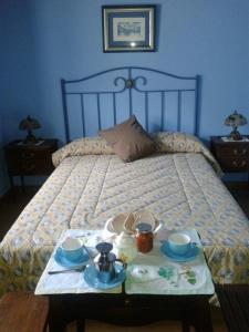 a bed with a tray of food on a table at Hospedaje - Ferrería Quintá in Quiroga