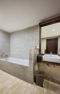 uma grande casa de banho com banheira e lavatório em Riss Hotel Malioboro em Yogyakarta