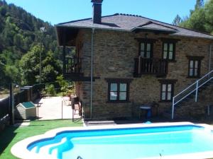 a house with a swimming pool in front of it at Hospedaje - Ferrería Quintá in Quiroga