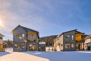 a house in the snow with the sun behind it at Aspects Big Sky in Big Sky