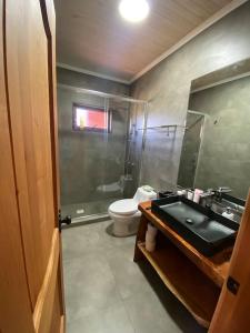 bagno con lavandino nero e servizi igienici di Cómodas y acogedoras cabañas a Huépil