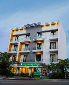 een wit gebouw met een bord ervoor bij ANGKOR SIVUTHA HOTEL in Siem Reap