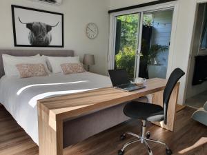 a bedroom with a bed and a desk with a laptop at Luxury private guest suite in the Blue Mountains in Springwood