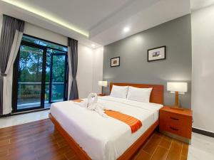 een slaapkamer met een groot bed en een raam bij ANGKOR SIVUTHA HOTEL in Siem Reap