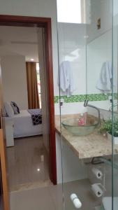 ein Badezimmer mit einem Waschbecken und ein Zimmer mit einem Sofa in der Unterkunft Pousada MarÍsis Barra da Tijuca in Rio de Janeiro