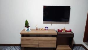 biurko z telewizorem na białej ścianie w obiekcie Casa no Campeche w mieście Florianópolis