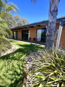 a house with a palm tree in front of it at Alexandra Motor Inn - Victoria Aus in Alexandra