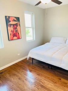 a bedroom with a bed and a painting on the wall at SPACIOUS & MODERN 3 BR HOME WI-Fi FREE PARKING in Chicago