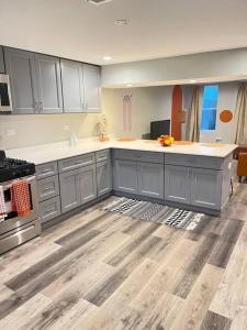 a kitchen with gray cabinets and white counter tops at SPACIOUS & MODERN 3 BR HOME WI-Fi FREE PARKING in Chicago