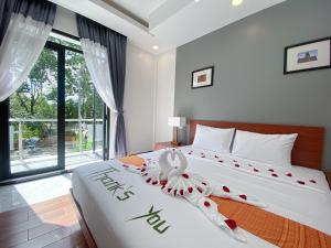 um quarto com uma cama grande com decorações em vermelho e branco em ANGKOR SIVUTHA HOTEL em Siem Reap