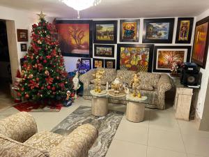 - un salon avec un arbre de Noël et un canapé dans l'établissement Hostal Ocean Pacifico, à Punta Negra