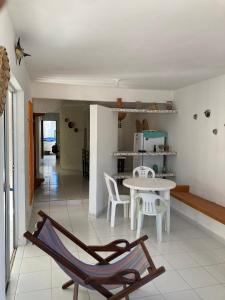 een woonkamer met een tafel en stoelen bij Casa Próxima ao Mar em Tamandaré - Seu refúgio a 20 m da praia in Tamandaré