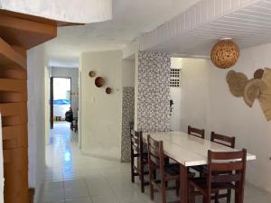 een eetkamer en een keuken met een tafel en stoelen bij Casa Próxima ao Mar em Tamandaré - Seu refúgio a 20 m da praia in Tamandaré