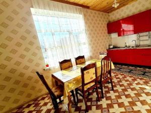 una cucina con tavolo, sedie e finestra di Mansion on the river a Yuxarı Lǝgǝr