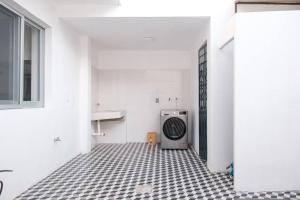 Habitación blanca con baño con lavadora. en Colomos, 5 BR w/AC king bed, backyard & parking., en Guadalajara