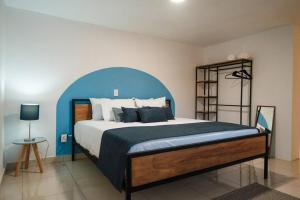 1 dormitorio con 1 cama grande y cabecero azul en Colomos, 5 BR w/AC king bed, backyard & parking., en Guadalajara